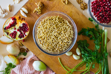 Grated walnuts with fresh herbs, garlic, pomegranate as part of Georgian traditional meal food -  chkapuli stew. Ingredients