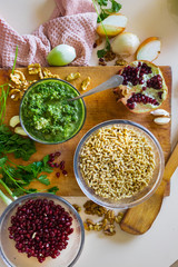 Pkhali ingredients: cilantro mixed with onion, garlic and green adjika, pomegranate, walnuts. Traditional Georgian food appetizer. Preparation process.