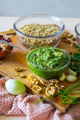 Pkhali ingredients: cilantro mixed with onion, garlic and green adjika, pomegranate, walnuts. Traditional Georgian food appetizer. Preparation process.