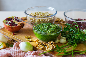Pkhali ingredients: cilantro mixed with onion, garlic and green adjika, pomegranate, walnuts. Traditional Georgian food appetizer. Preparation process.