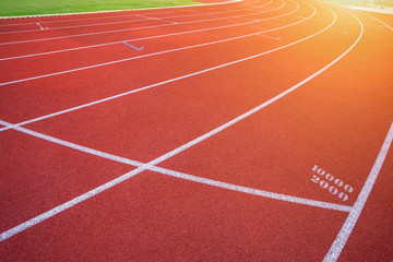 White lines of stadium and texture of running racetrack red rubber racetracks in outdoor stadium are 8 track and green grass field,empty athletics stadium with track.