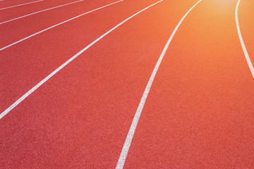 White lines of stadium and texture of running racetrack red rubber racetracks in outdoor stadium are 8 track and green grass field,empty athletics stadium with track.