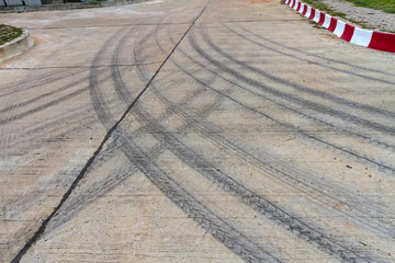 Pattern of tire tracks on cement road.