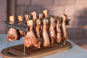 raw Chicken thighs inserted in a special holder of stainless steel for roasting in the oven