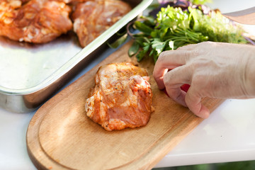 Cook's hand  and Chicken meat on a cutting board