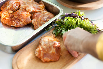 Cook's hand  and Chicken meat on a cutting board