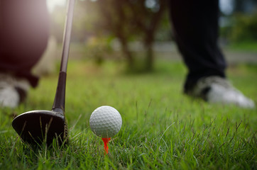 The golf ball and golf club with the warm light of the evening