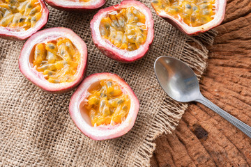 Passion fruit or Passiflora edulis cut into halves on wooden table