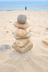 Fototapeta na wymiar Balanced rocks are left on the beach in a zen type atmosphere