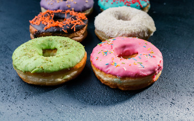 Donuts with a colorful icing on a dark background