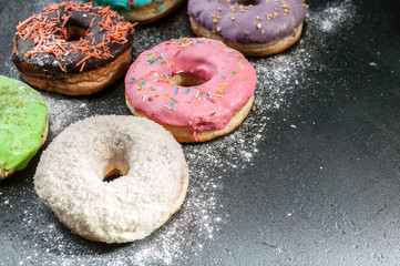 Donuts with a colorful icing on a dark background