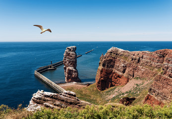 Fototapeta premium high angle view of Lange Anna sea stack rock on Heligoland island against blue sea and clear sky