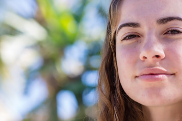 Young woman looks down in late afternoon sun with room for copy text