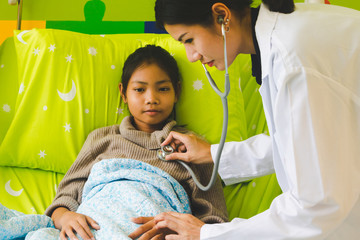 Doctor is listening to the heart by using a sethoscope and examining the patient.