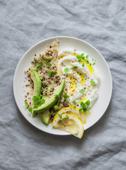 Greek yogurt with avocado, quinoa, greens, spice bowl on grey background, top view. Healthy appetizer, tapas