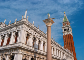 Fototapeta na wymiar The column of St. Theodore and the bell tower of St. Mark-Campanile-in the center of Venice. In the background, the clock tower