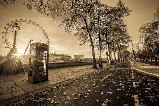 Red telephone booth isolated on black and white street