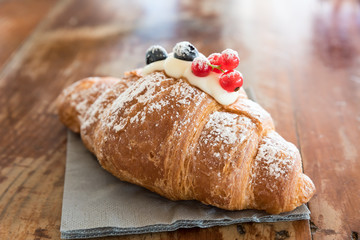 Croissant filled with mascarpone and garnished with cranberries and currants