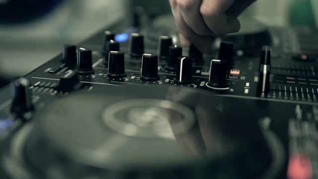 DJ tweak track controls on DJ control panel.