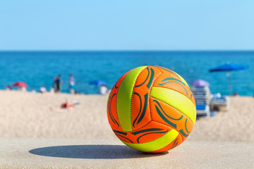ball lying on a stone parapet on a sandy beach background