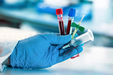 lab technician hand holding blood collection tubes and catheter with tube holder / laboratory...