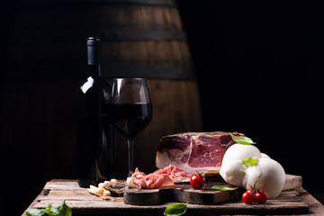 Fototapeta na wymiar Bottle of wine with a glass on a table with rustic traditional italian food.Fresh tipical italian lifestyle