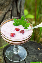 Healthy wild strawberry ismoothie or ice cream vintage glass. Natural wooden background. Top view. Selective focus. Copy space. Summer super food.