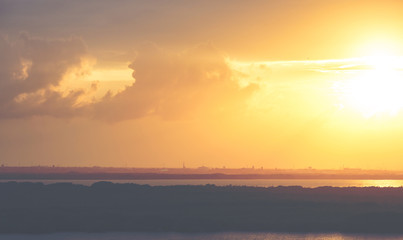 Sunset with vintage effect in the Caribbean sea shore. Cityscape in the background.