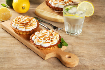 Lemon pie with meringue and lemonade on a wooden table