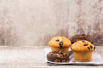Homemade muffins with chocolate, vintage background.