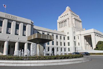 Obraz premium The unique, classic granite central tower of the National Diet Building of Japan, the meeting place of the national government, rises into a blue sky in Tokyo. National diet building -Kokkaigijido