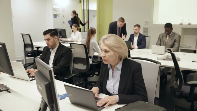 Business people working and communicating together in modern open plan office