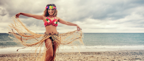 Beautiful and happy hawaiian woman portrait dancing on the beach, letterbox