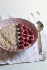 Bowl of overnight oats made with banana, milk and peanut butter smoothie with added rasperries and chia seeds. Selective focus.  