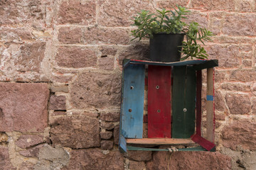 A painted chest and a succulent pot on vinatge wall in Cunda, Ayvalik, Turkey