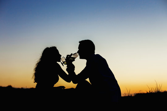 Enamored couple embraced at sunset in a backlit photo