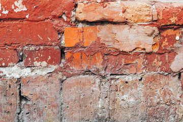 The texture of the old red brick wall with scratches and cracks