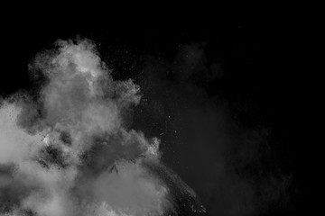 Bizarre forms of  white powder explosion cloud against dark background. Launched white particle splash on black background.