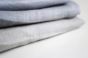 Three kinds of different cloth in a stack on a white table close up.