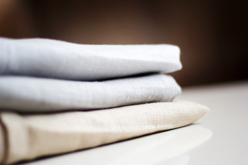 Three kinds of different cloth in a stack on a white table close up.