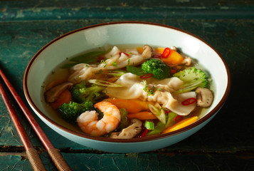 Bowl of tasty oriental wonton soup with vegetables
