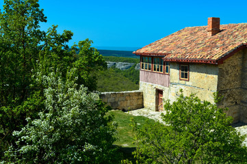 Fototapeta na wymiar Old stone house with a tiled roof high in the mountains surround the green trees.