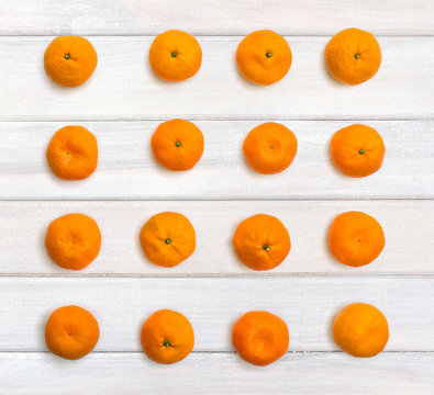 Fresh mandarin oranges on background of white painted wooden planks. Top view, flat lay