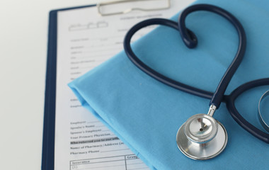 A stethoscope shaping a heart on a medical uniform, closeup, selective focus