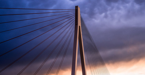 Fototapeta na wymiar High suspended road bridge in Germany against a dark stormy sky at sunset.