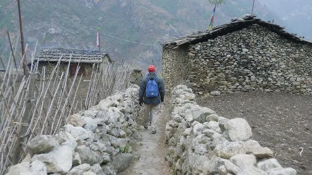 Tourists walking in nepalese village Prok, trek around mountain Manaslu, Nepal.