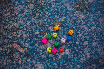 Wooden multicolored letters spelling just married with rings on marble