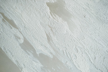 Decorative plaster applied on the wall with light strokes of white color