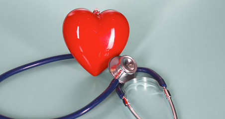 Red heart with stethoscope on blue wooden background. Copy space. Valentines day.
