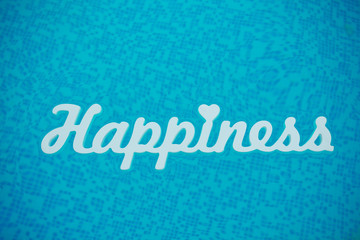 white wooden inscription of happiness floating on blue water